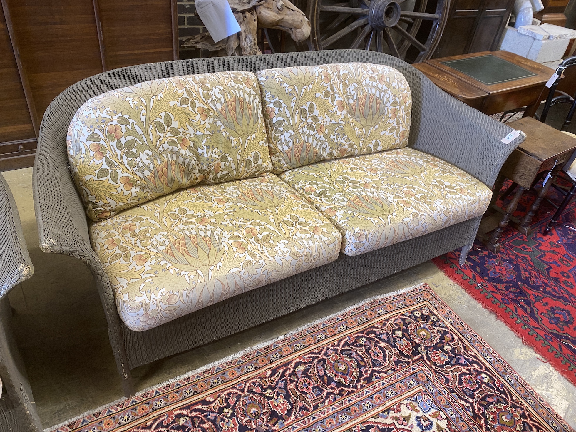 A pair of Lloyd Loom garden settees with William Morris fabric cushions, width 187cm, depth 74cm, height 81cm